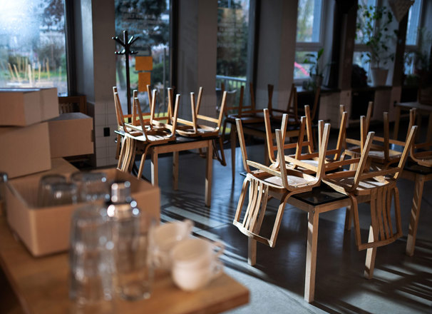 Closed restaurant with chairs overturned on tables