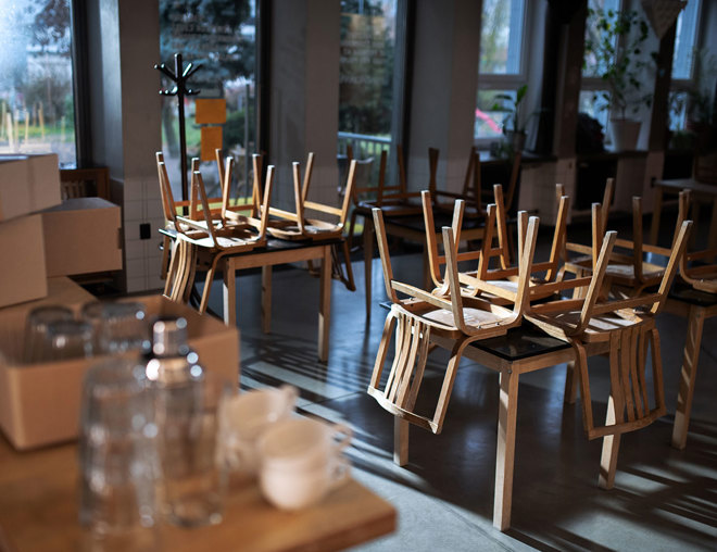 Closed restaurant with chairs overturned on tables