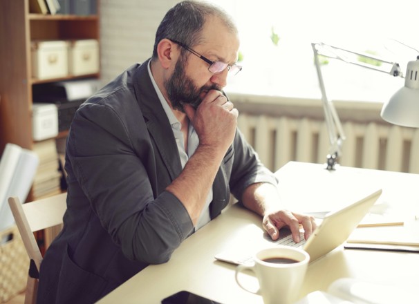 Man thinking while using laptop at his desk