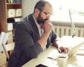 Man thinking while using laptop at his desk