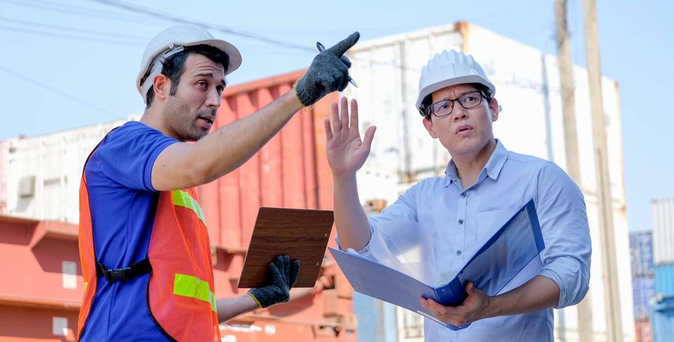 Workers arguing over placement of shipping containers.