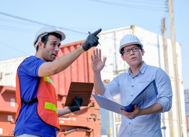 Workers arguing over placement of shipping containers.