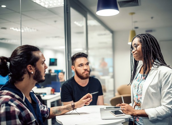 Three coworkers having a disagreement in a meeting room.