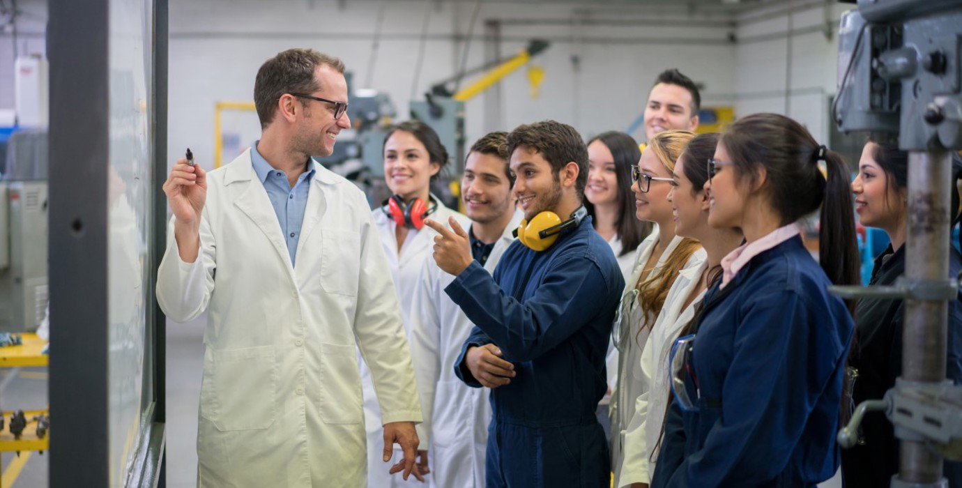 Teacher instructing engineering students.