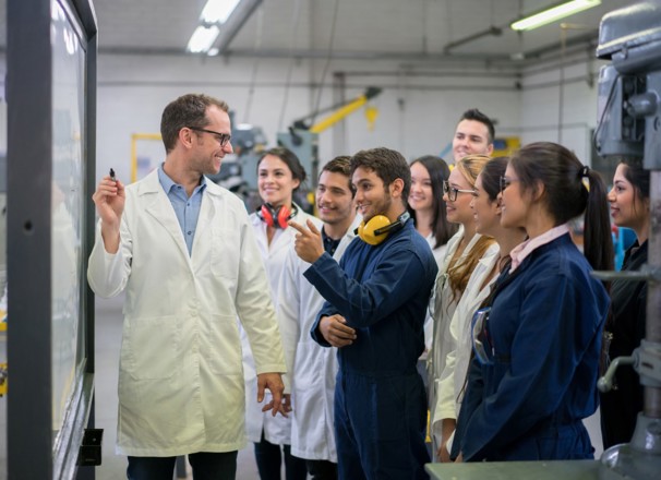 Teacher instructing engineering students.