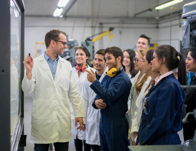 Teacher instructing engineering students.