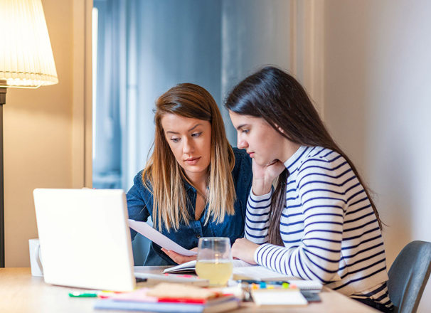 Mother helping her daughter with homework.