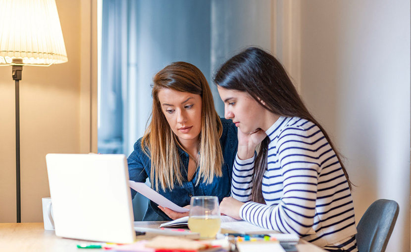 Mother helping her daughter with homework.