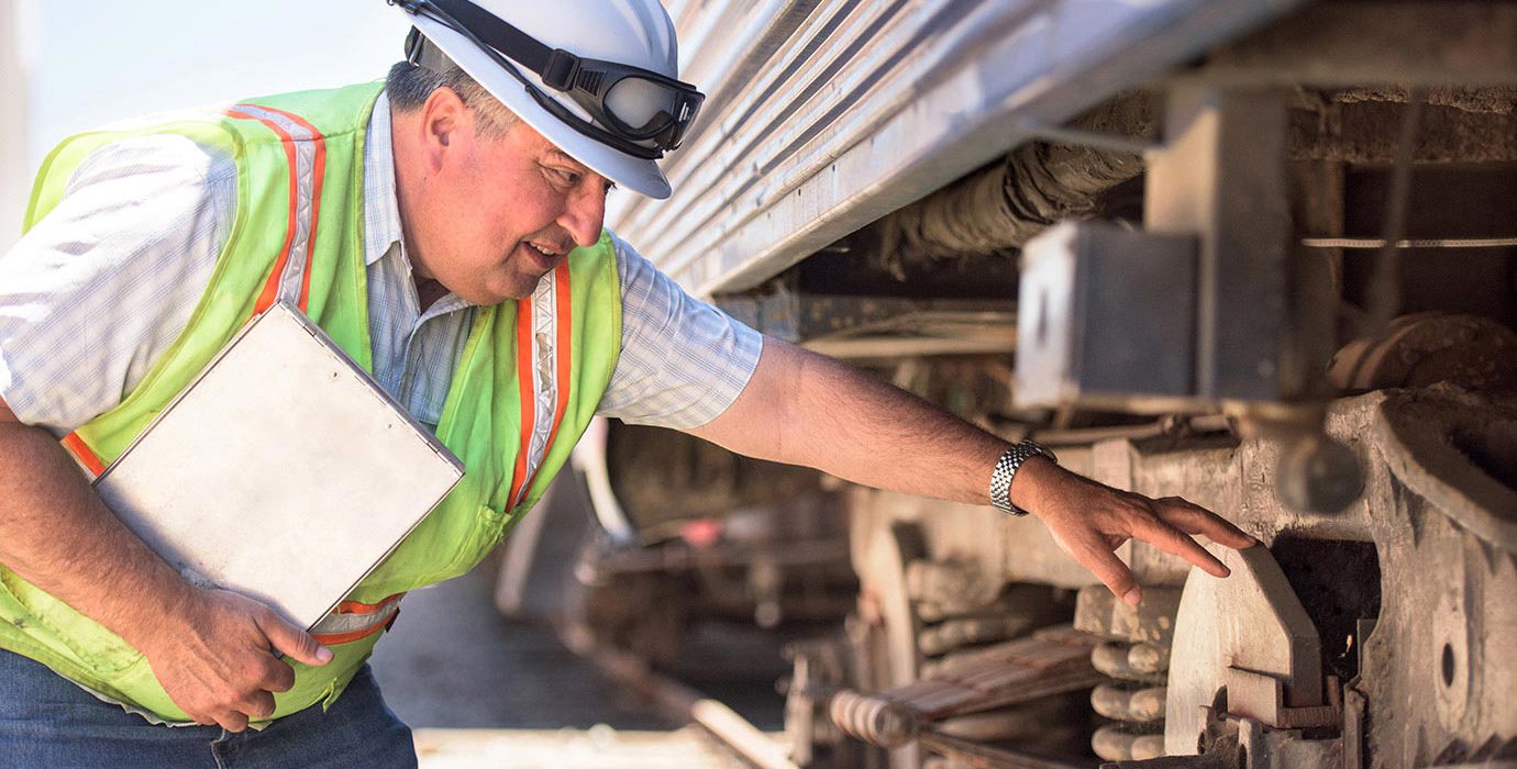 Railroad worker inspecting a train.