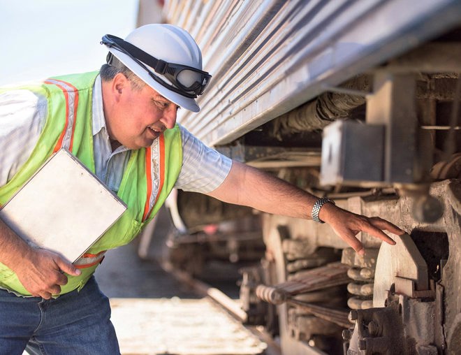 Railroad worker inspecting a train.