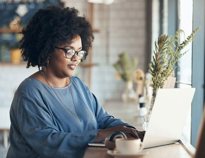Woman working on her laptop in a coffee shop.