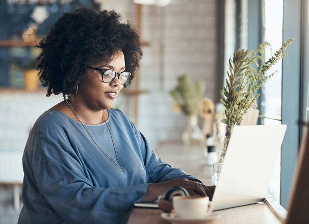 Woman working on her laptop in a coffee shop.
