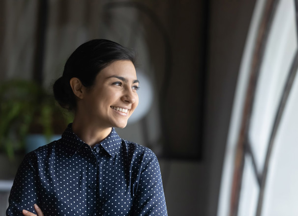 Woman smiling and looking out of a window.