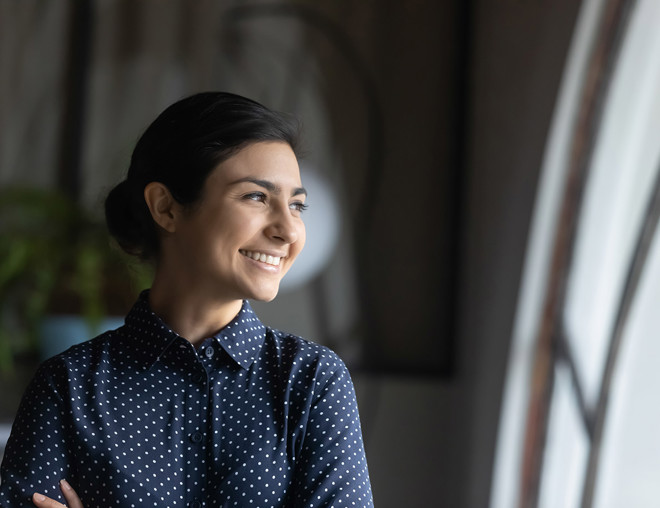 Woman smiling and looking out of a window.