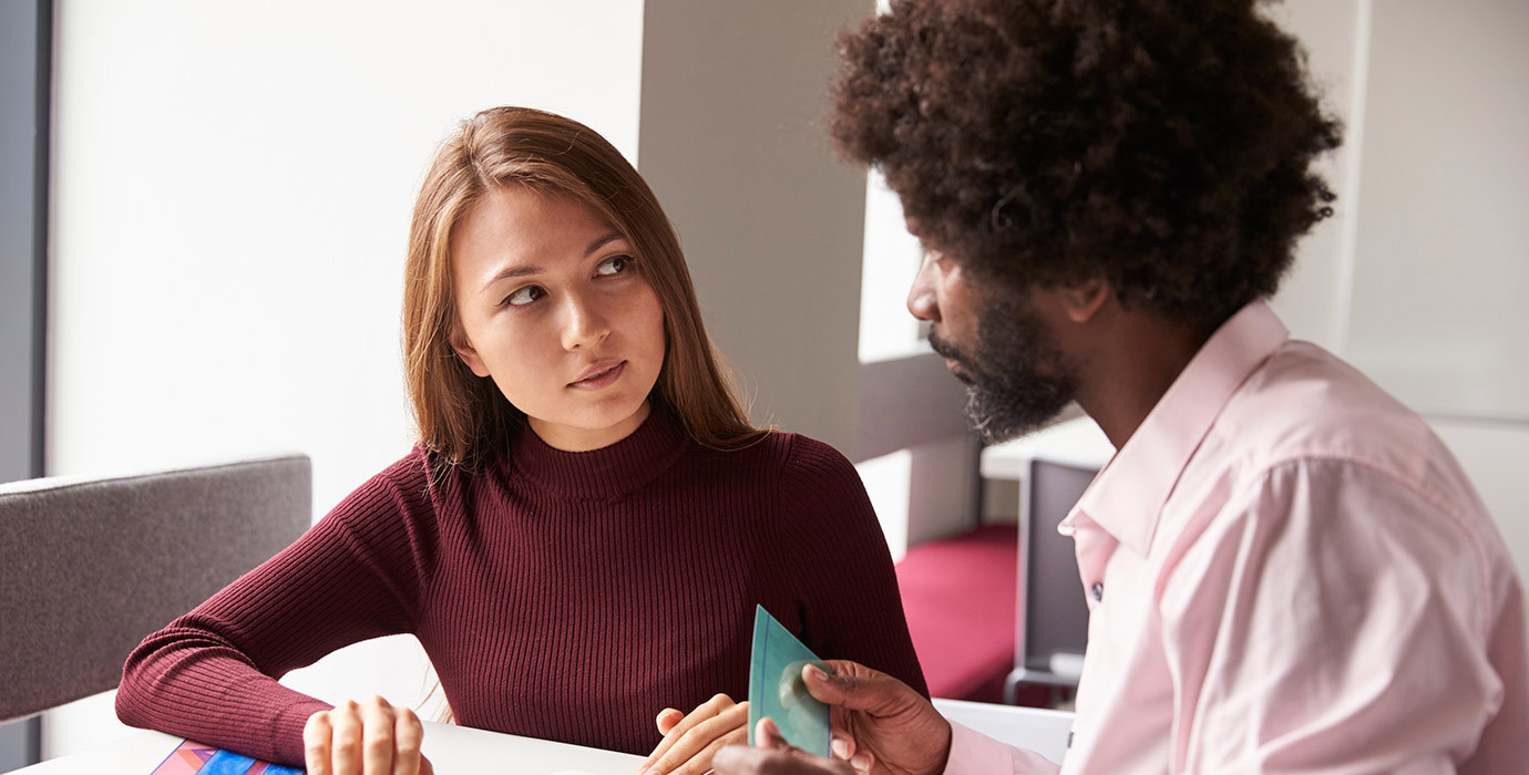A person working with a tutor while using learning aids.