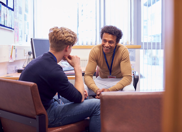 A student sitting in an office chatting with a counsellor.