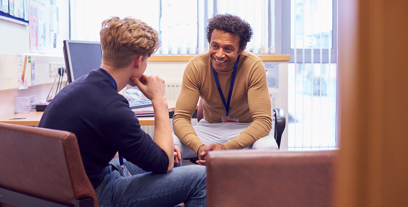 A student sitting in an office chatting with a counsellor.