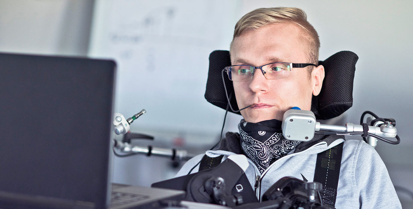 A student with a disability using assistive technology in a classroom.