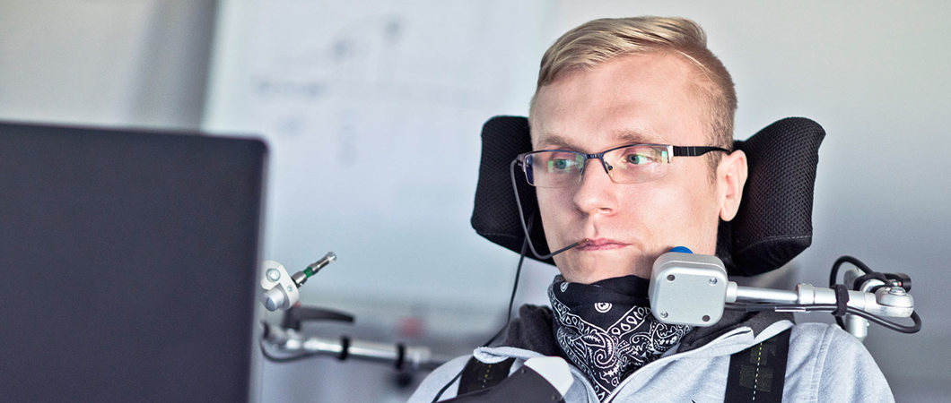 A student with a disability using assistive technology in a classroom.