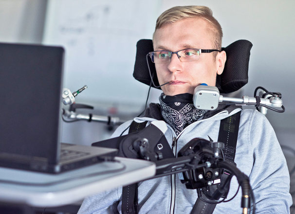 A student with a disability using assistive technology in a classroom.