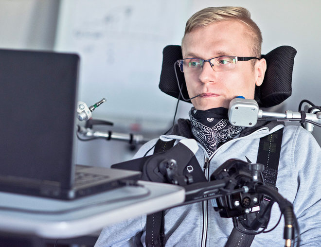 A student with a disability using assistive technology in a classroom.