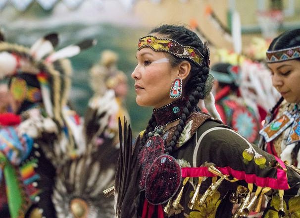 A dancer from Semiahmoo First Nation wearing traditional clothing pauses during a pow wow.