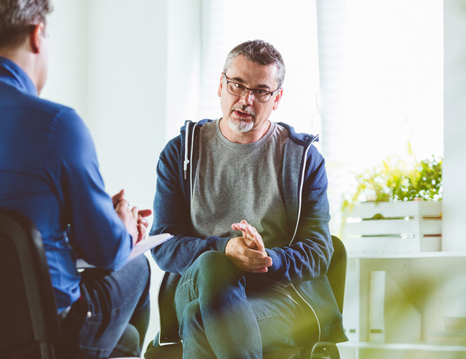 A mature person converses with a therapist.