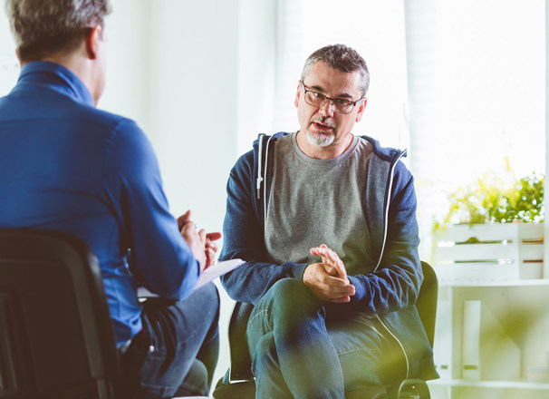 A mature person converses with a therapist.