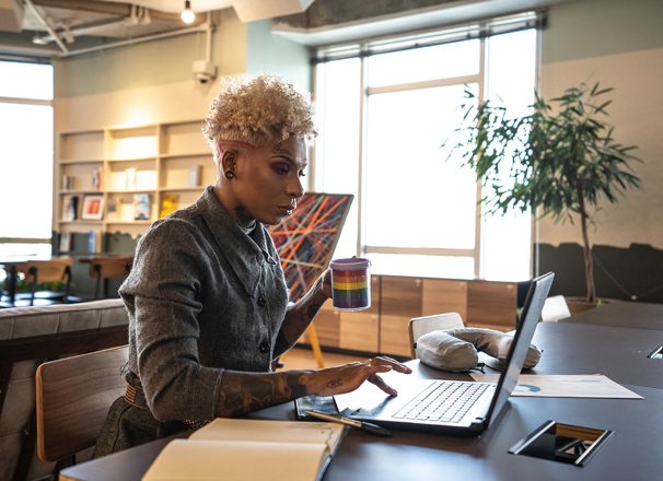 A businessperson works with a laptop in a coworking space.