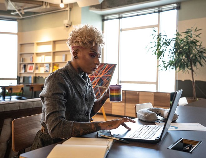 A businessperson works with a laptop in a coworking space.