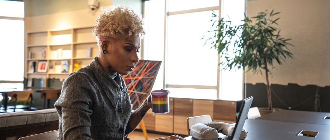 A businessperson works with a laptop in a coworking space.