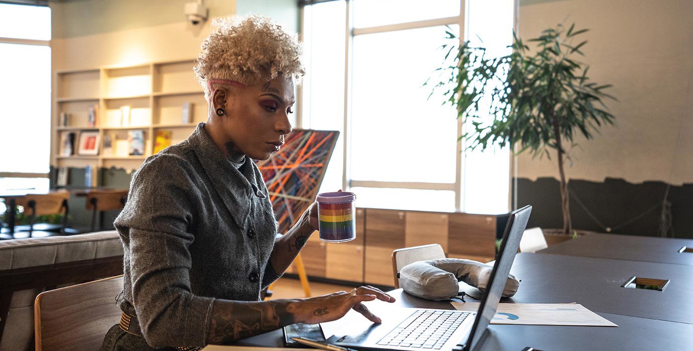 A businessperson works with a laptop in a coworking space.