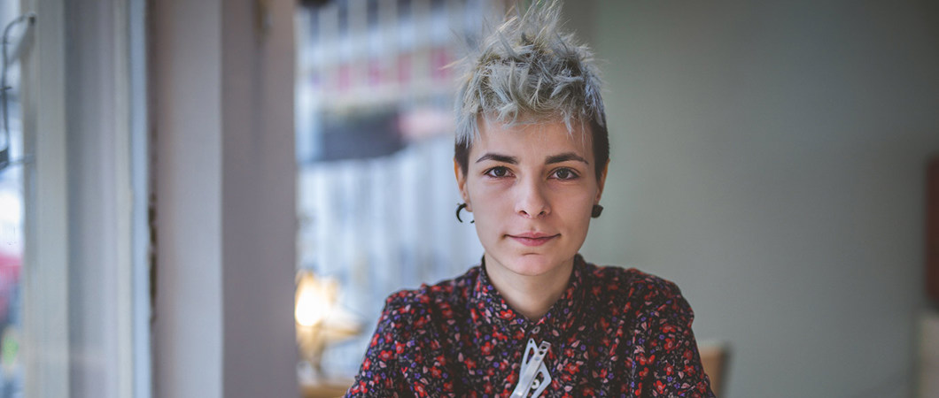 A portrait of a person sitting at a cafe table.