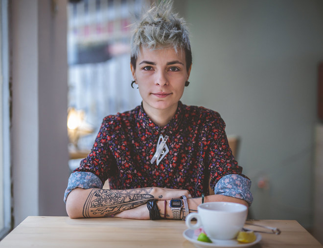 A portrait of a person sitting at a cafe table.