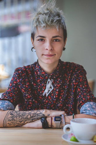 A portrait of a person sitting at a cafe table.