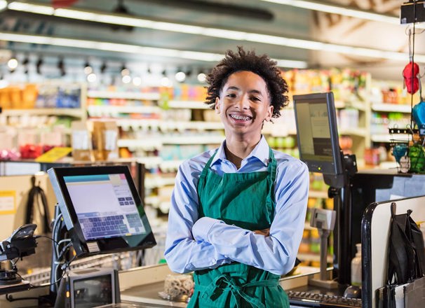 A portrait of a young cashier at a grocery store.