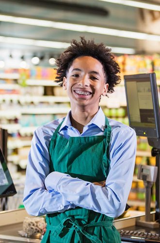 A portrait of a young cashier at a grocery store.