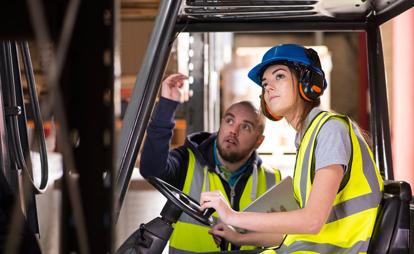 A forklift driver trains with another worker.