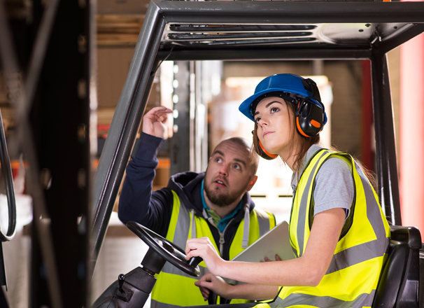 A forklift driver trains with another worker.