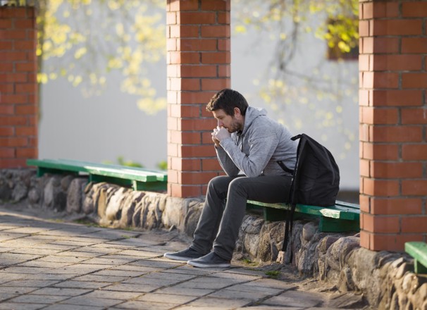 Mature student sitting anxiously outside of school.