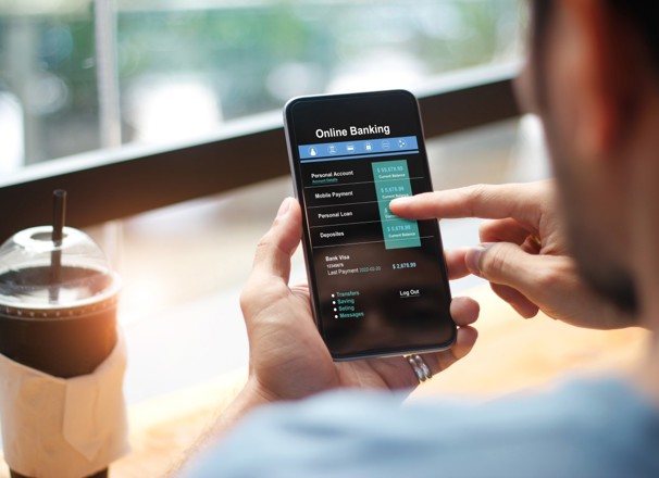 Person doing online banking from their smartphone in a cafe.