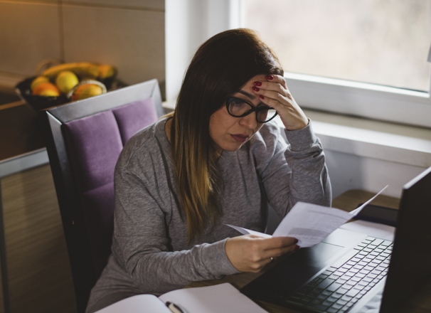Concerned looking person reviewing a paper at their desk.