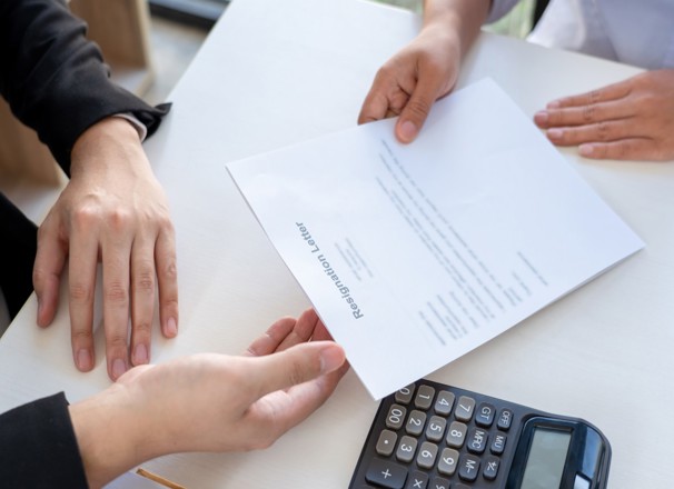 Employee handing their employer a resignation letter.