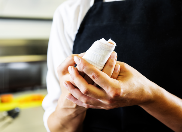 Chef holding injured finger in kitchen.