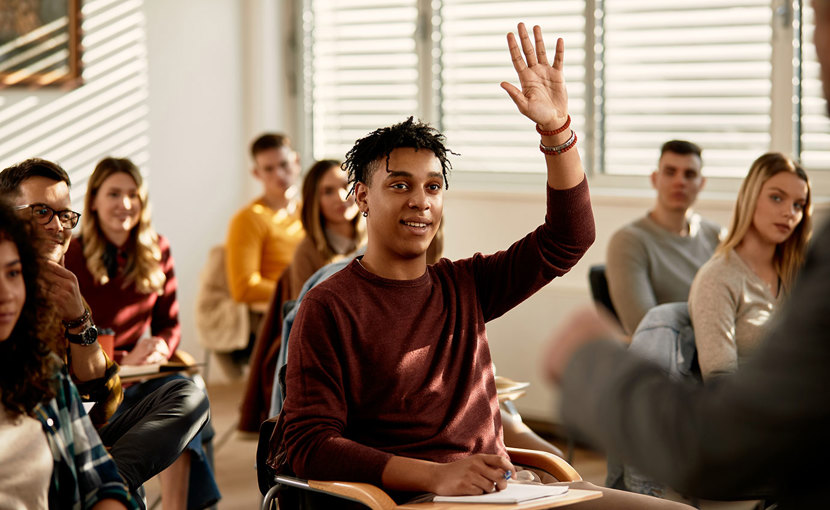 Student raising hand in classroom