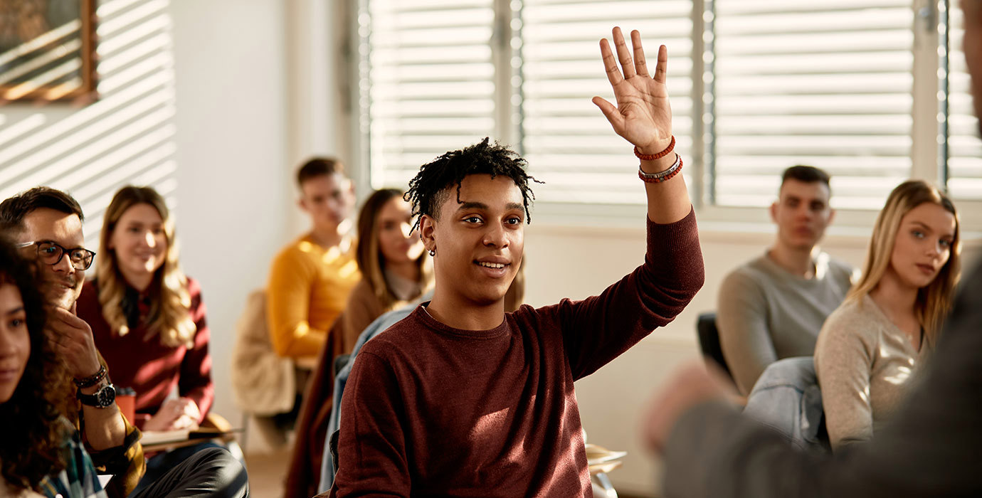 Student raising hand in classroom