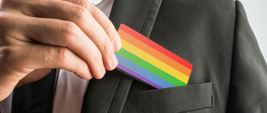 LGBT pride flag business card being pulled out of suit pocket