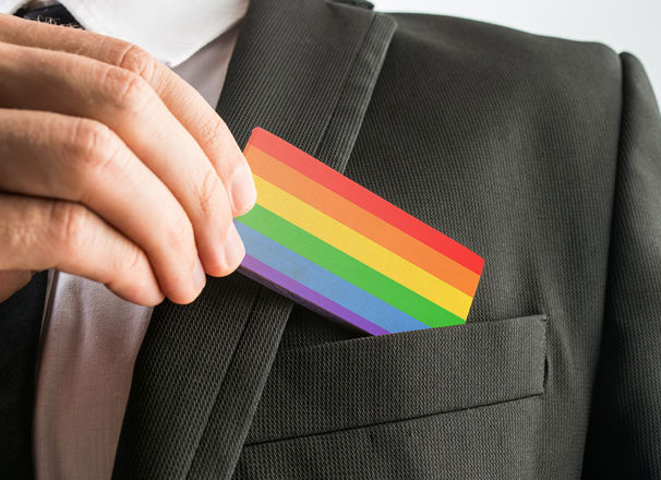 LGBT pride flag business card being pulled out of suit pocket
