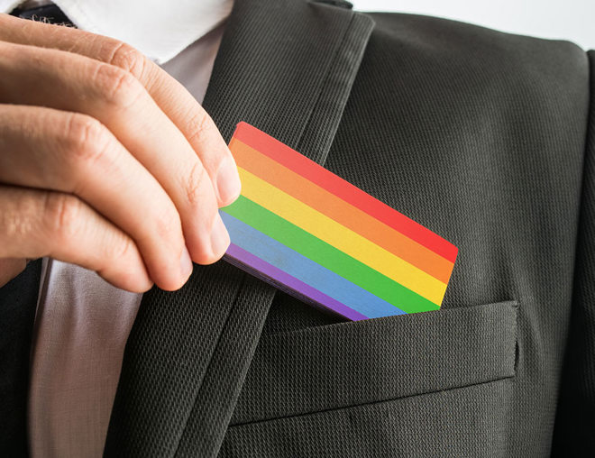 LGBT pride flag business card being pulled out of suit pocket