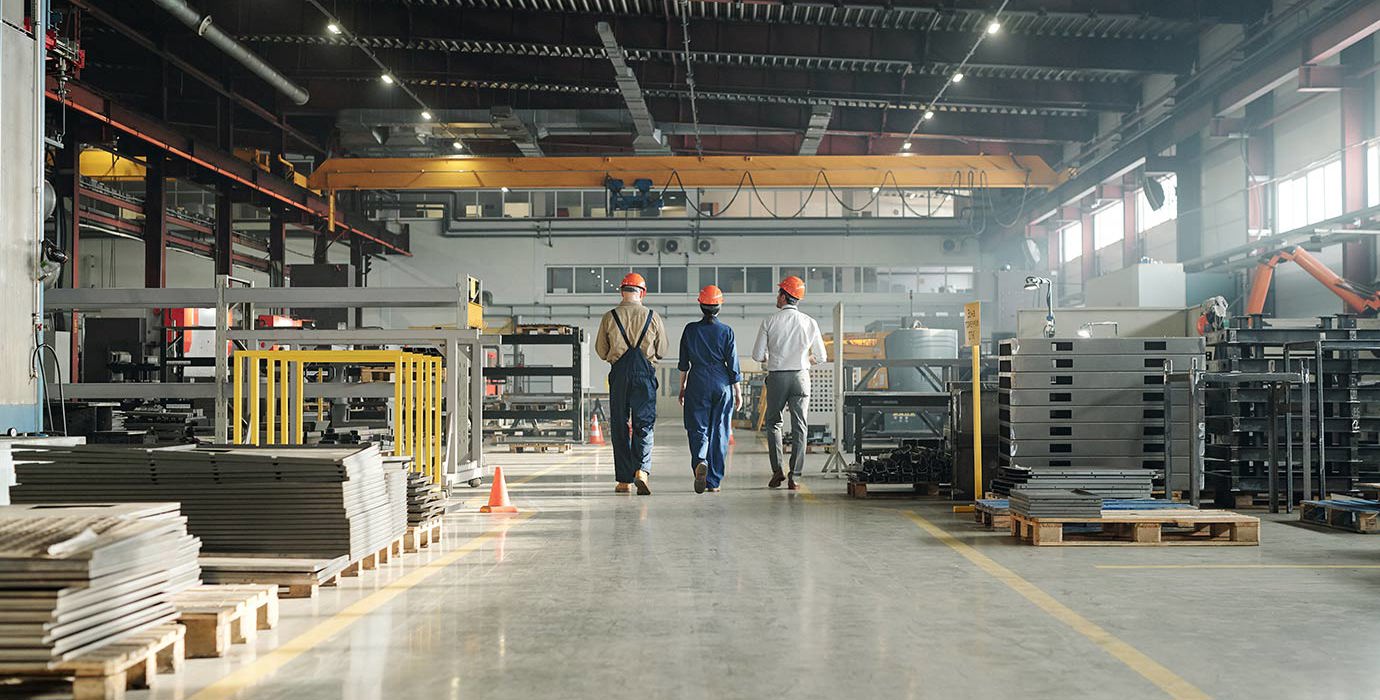 3 workers walking through an industrial building
